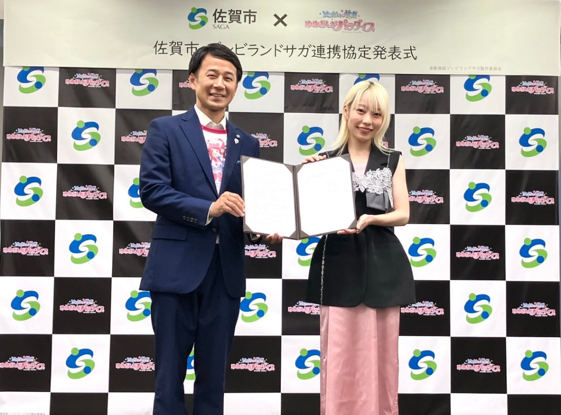 アニメ「ゾンビランドサガ」シリーズと佐賀市の連携協定の発表会に登場した坂井英隆市長（左）と本渡楓さん（C）劇場版ゾンビランドサガ製作委員会